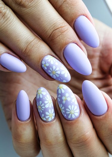 Elegant pastel lavender nails with floral designs, showcasing chic almond shapes and matte finish.