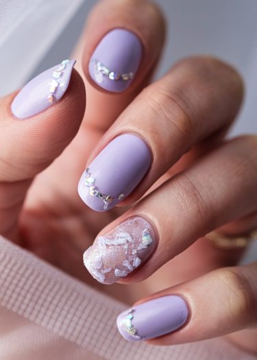 Elegant pastel lavender manicure with reflective nail art and textured design for a glamorous look.