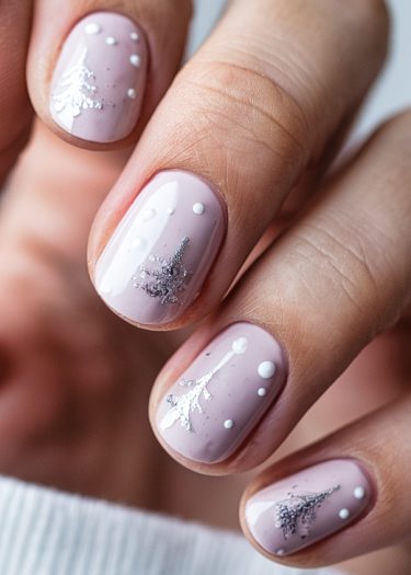 Elegant pastel pink winter nail art featuring silver Christmas trees and white snowflakes.