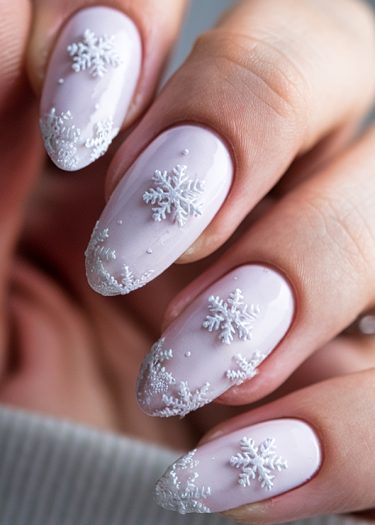 Pastel lavender nails with white snowflake designs, perfect for winter manicures.