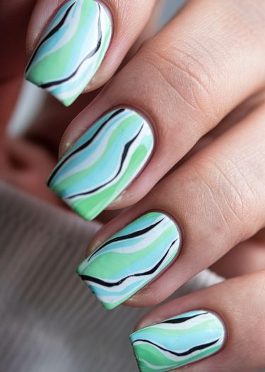 Vibrant pastel-patterned nail art with unique designs and elegant fingernails showcased in close-up.