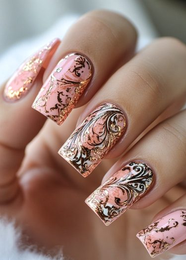 Elegant blush pink nail art with intricate black and gold designs for a luxurious look.