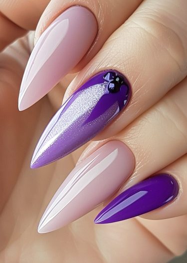 Elegant stiletto nails with pastel pink and bold purple gradient design, featuring intricate black artwork.