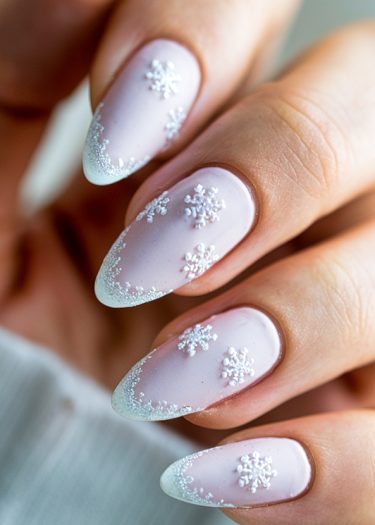 Elegant pastel pink nails with intricate snowflake designs and glittery frost tips.