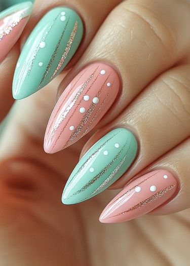 Chic pastel stiletto nails in mint green and coral pink with gold glitter accents.