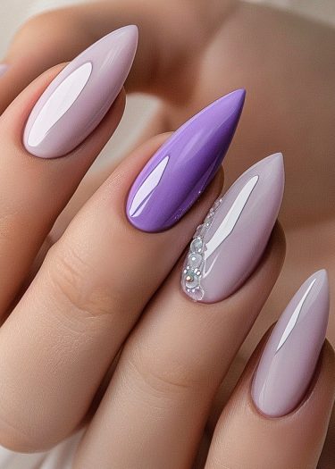 Elegant pastel stiletto nails with intricate detailing and a bold violet accent nail.