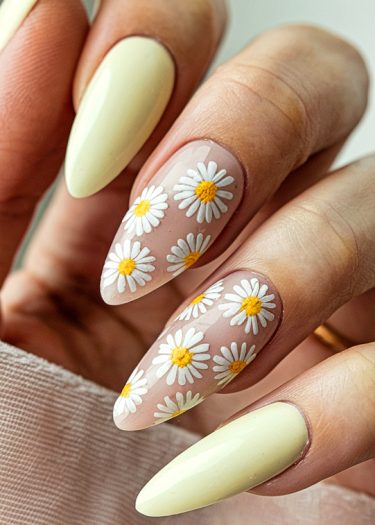 Elegant pastel yellow and daisy nail art on almond-shaped nails for a stylish manicure.