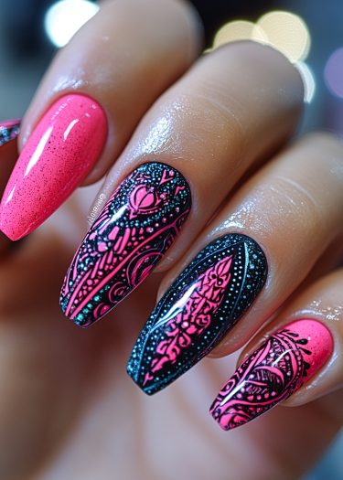 Exquisite pink and black nail art with intricate designs on manicured almond-shaped nails.