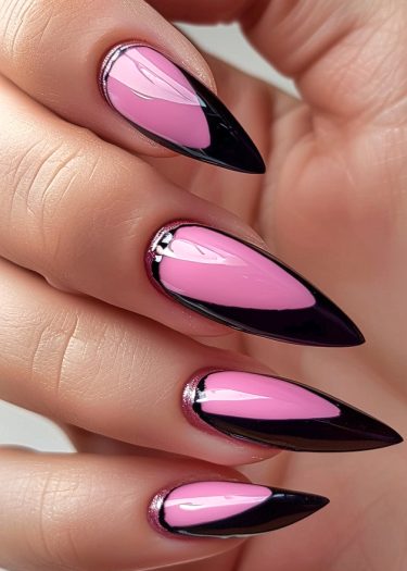 Elegant almond-shaped pink and black nail art with sleek stiletto tips and silver accents.