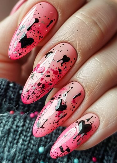 Stunning pink gradient stiletto nails with black and red designs and glitter accents.