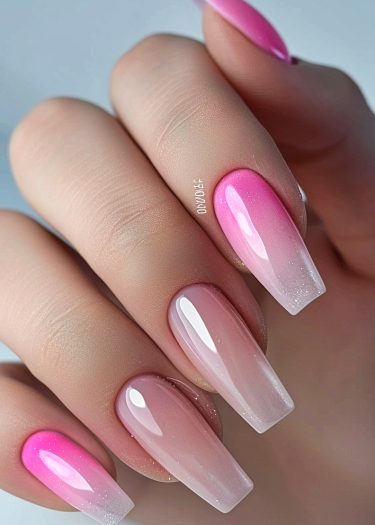 Elegant pink ombre coffin nails with glossy finish and shimmering accents for a fashionable look.