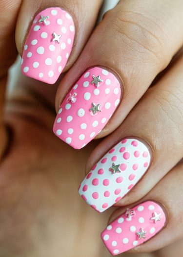 Playful pink and white polka dot nail art with star embellishments and a manicured finish.