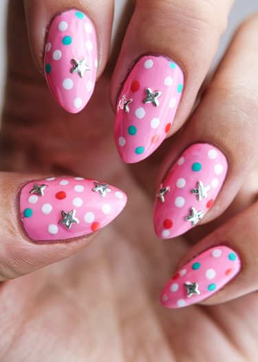 Playful pink polka dot nails with star embellishments create a whimsical and vibrant nail art design.