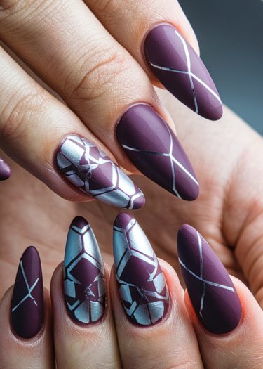 Elegant plum geometric nail art design with glossy finish and metallic accents.