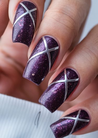 Sophisticated purple nail art with silver crisscross design and glitter accents.