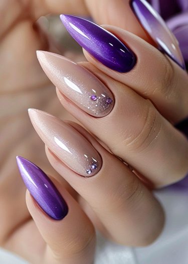 Elegant stiletto nails featuring purple and nude shades with rhinestone embellishments for a sophisticated look.