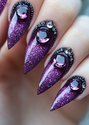 Striking purple glitter stiletto nails adorned with gemstones and black rhinestones for a luxurious look.