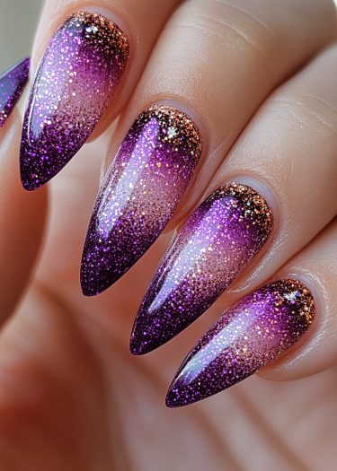 Stunning stiletto nails with purple gradient and glitter for a glamorous manicure look.