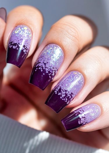 Elegant purple gradient glitter nails with sparkles and a glossy finish.