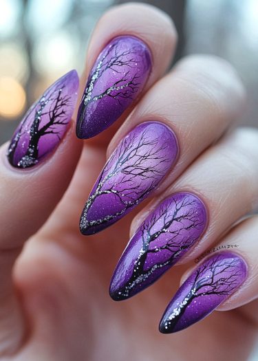 Stunning winter-themed purple gradient stiletto nails with intricate tree silhouettes and shimmering glitter.