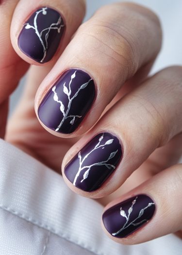 Elegant purple matte nail art with intricate silver designs showcasing sophisticated style.