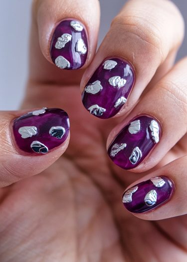 Elegant purple metallic nail art with abstract silver accents for a modern, stylish look.