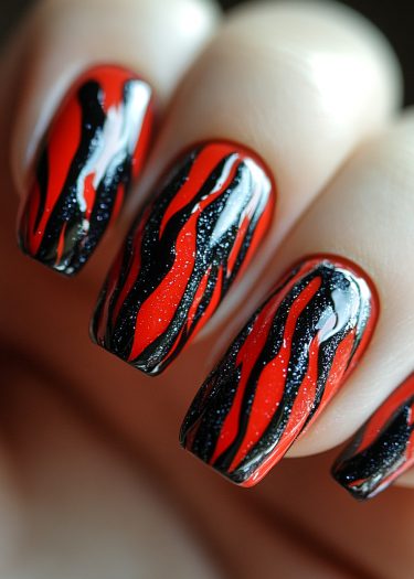 Stunning black and red flame nail art with glitter and long squared tips.