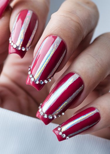 Elegant red coffin nails with holographic stripes and silver glitter, adorned with rhinestones.