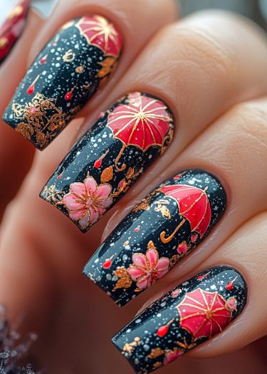 Elegant black nail art featuring red umbrellas and gold accents, perfect for special occasions.