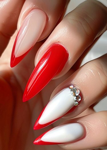 Elegant red and white stiletto nail art with crystals and glossy finishes for a chic look.