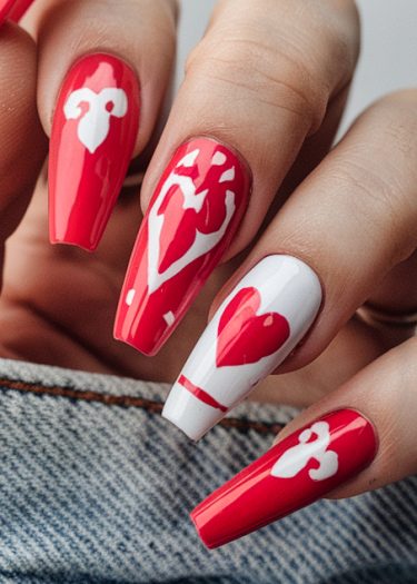 Stunning red and white nail art design with heart motifs on a denim background.