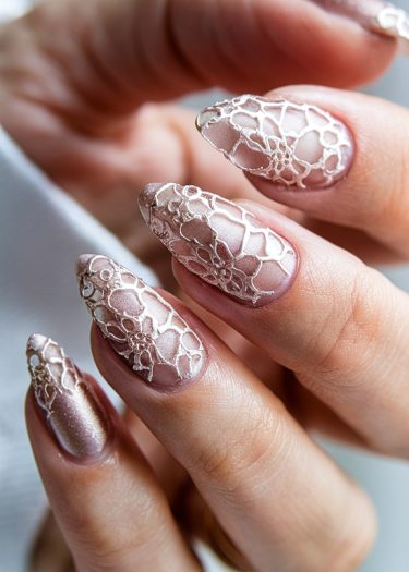 Elegant rose gold lace nail art with intricate designs and shimmery metallic finish.