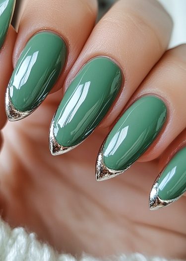 Elegant almond-shaped nails in glossy olive green with metallic silver tips for a chic look.