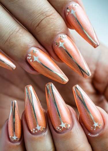 Stiletto nails with shimmering peach color and intricate celestial star design for elegant nail art.