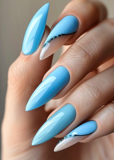 Sophisticated sky blue stiletto nails with rhinestone accents for elegant manicures.