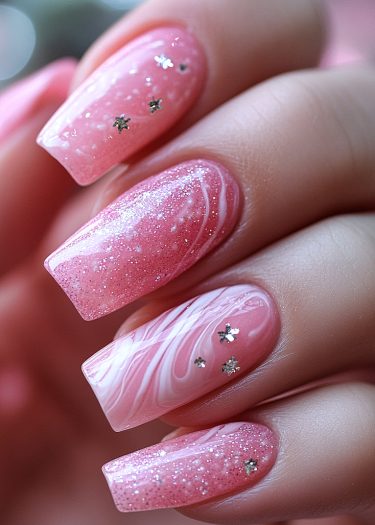 Elegant soft pink coffin nails with glitter, marble designs, and star embellishments.