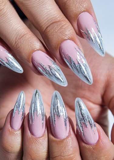 Elegant soft pink stiletto nails with metallic silver chrome design for a bold manicure look.