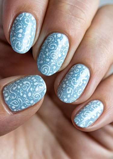 Elegant pastel blue nail art with intricate white swirls and dots for a chic look.