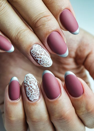 Elegant mauve nails with lace design and metallic tips for a chic manicure look.