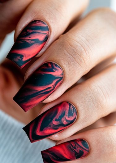 Intricate red and black marbled nail art with a bold square shape for a sophisticated look.