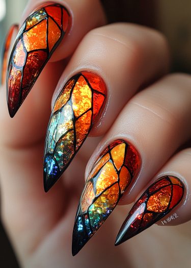 Vibrant stained glass stiletto nails featuring bold colors and intricate designs.