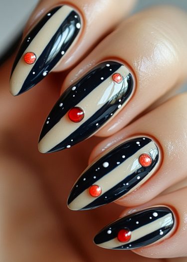 Elegant black and nude striped almond nails with red accents and white dots.