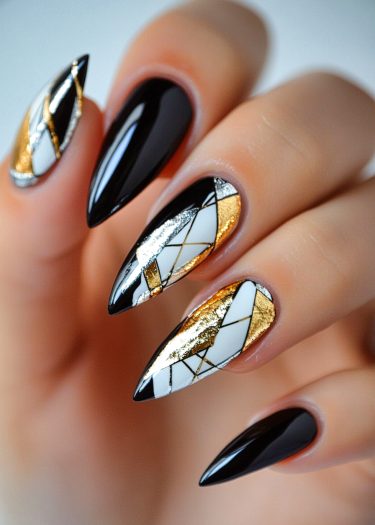 Elegant stiletto nails with black and geometric metallic designs showcase high-fashion nail art.