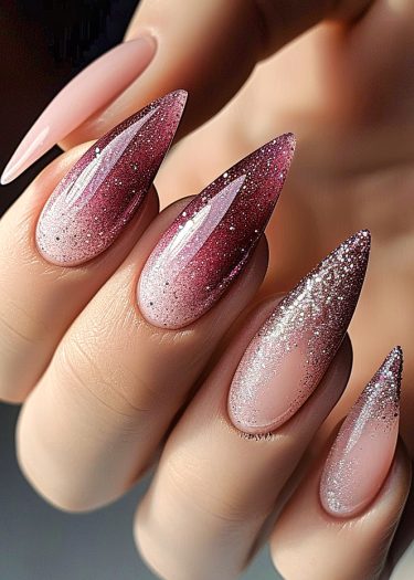 Stunning stiletto nails with pink-to-magenta gradient and glamorous glitter for elegant style.