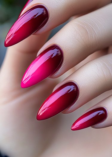 Elegant almond stiletto nails featuring a stunning burgundy to pink gradient polish.