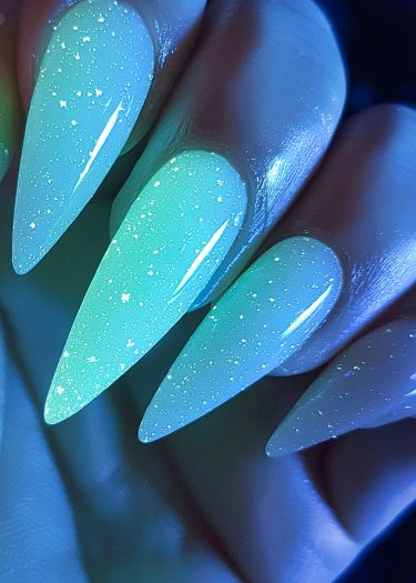 Stunning stiletto gradient nails in teal with sparkling shimmer create an elegant nail art masterpiece.