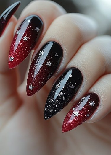 Stunning almond-shaped stiletto nails with a red-to-black gradient and silver star decals.