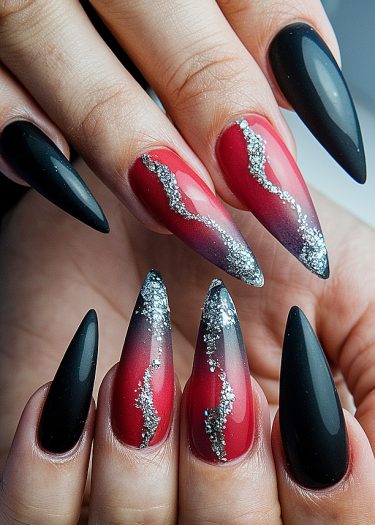 Stunning stiletto nail art in black and red with silver glitter, perfect for bold statements.