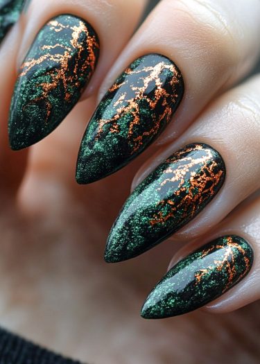 Elegant deep green almond-shaped nails with striking metallic copper veins for edgy nail art.