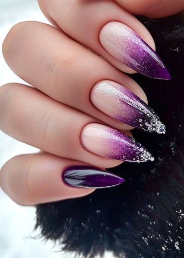 Elegant ombre stiletto nails in purple and beige with glitter, resting on luxurious fur.